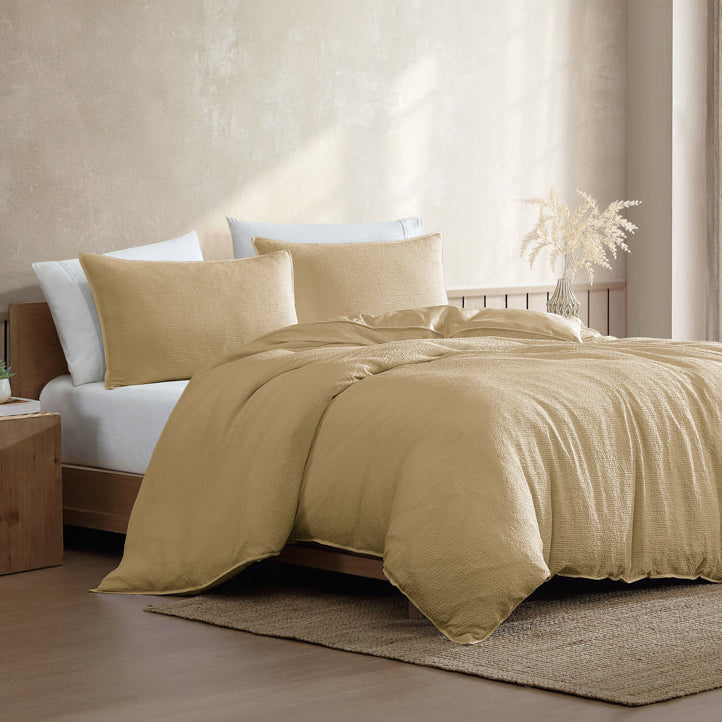 Yellow bedding set on a bed in a bedroom with natural light