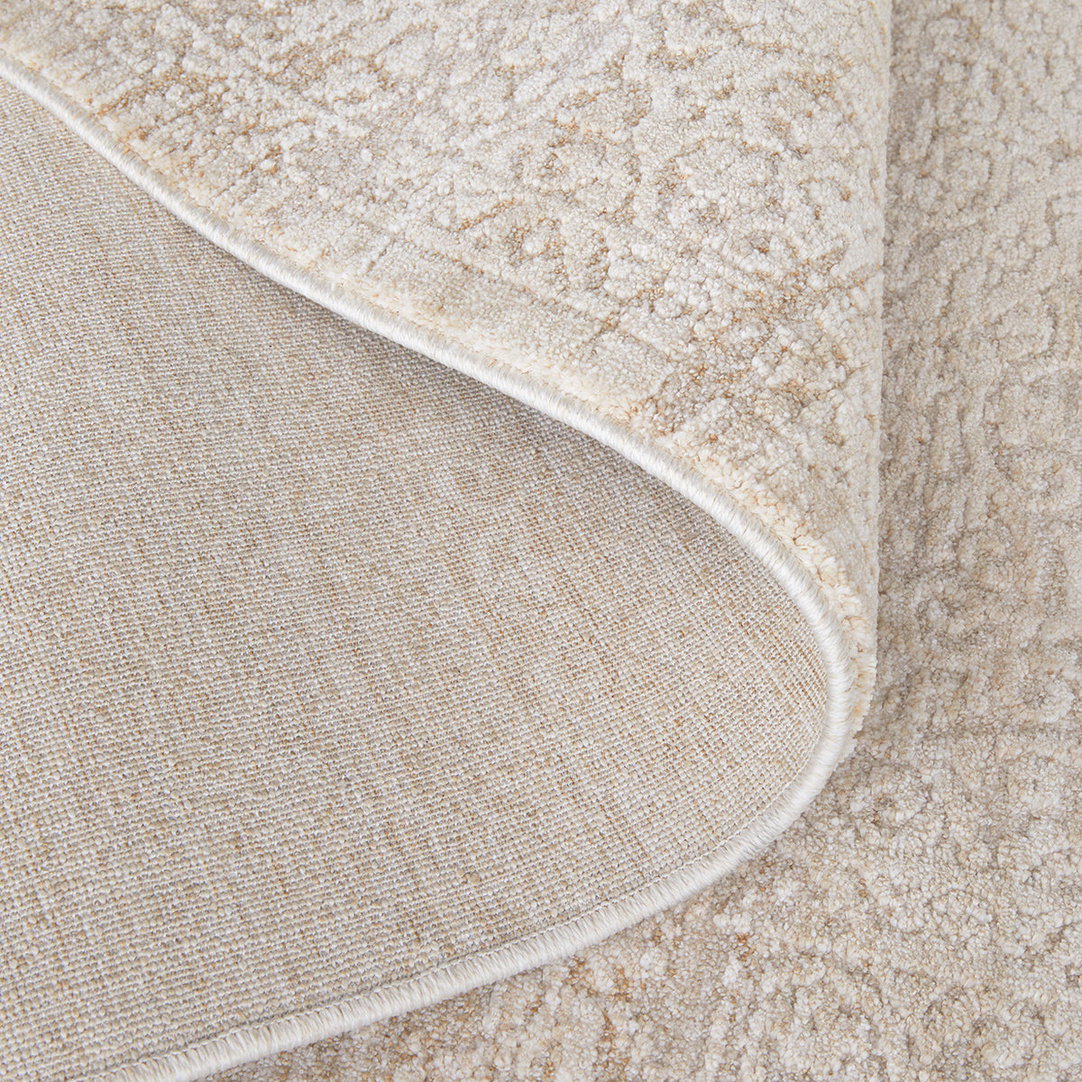 Emma Blomfield Veil natural rug with folded corner revealing woven backing and subtle lacy pattern