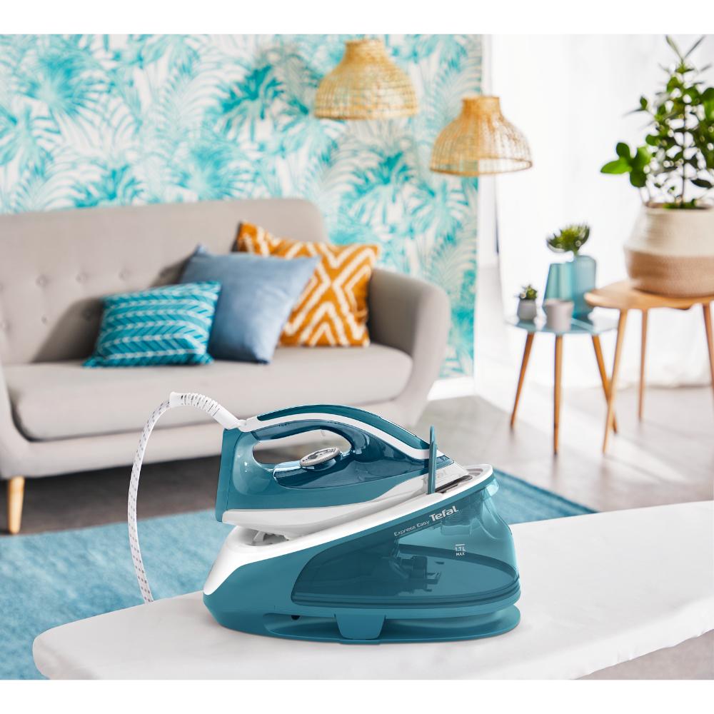 blue steam iron on an ironing board in the loungeroom - MyHouse
