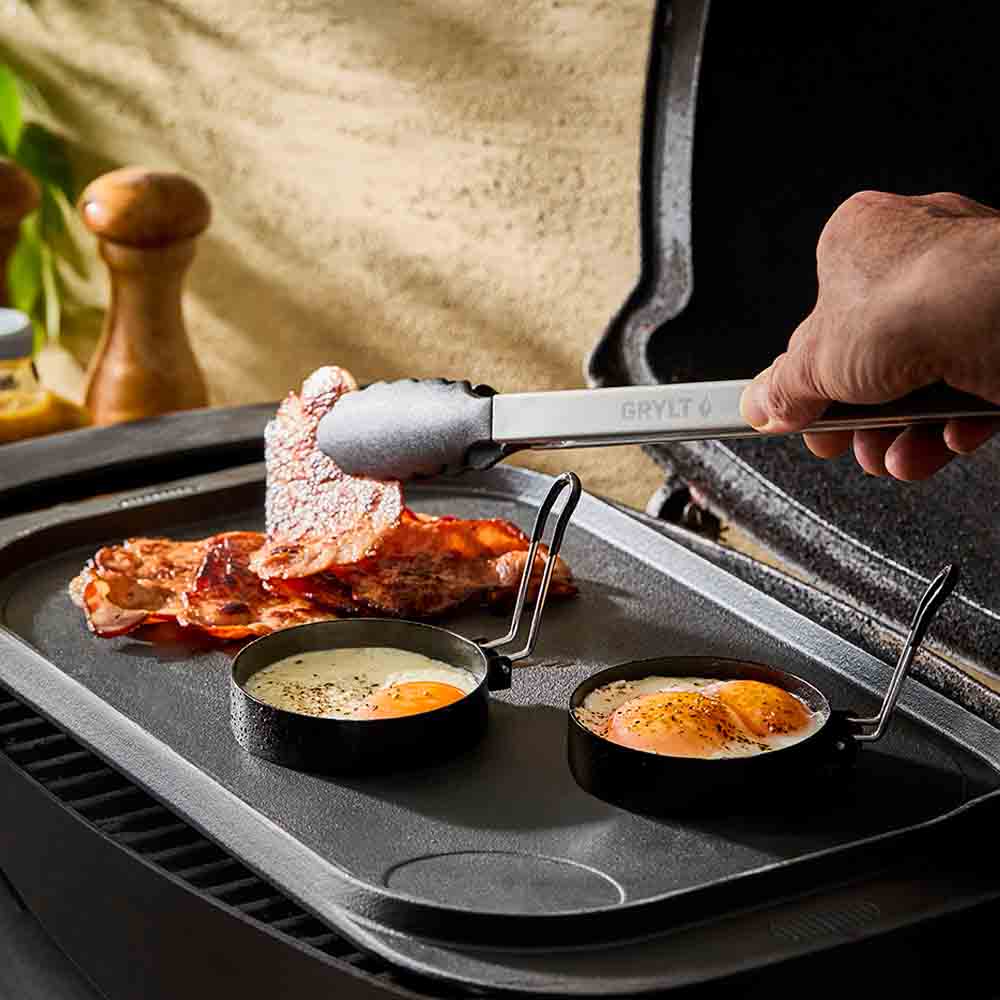 man picking up bacon using long handled BBQ tongs - MyHouse
