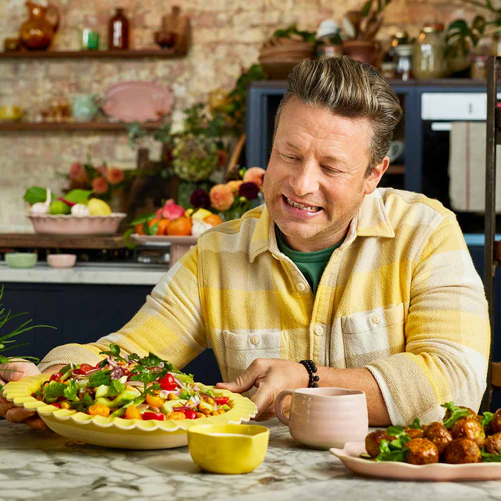 Jamie Oliver holding a large yellow serving bowl full of salad - MyHouse