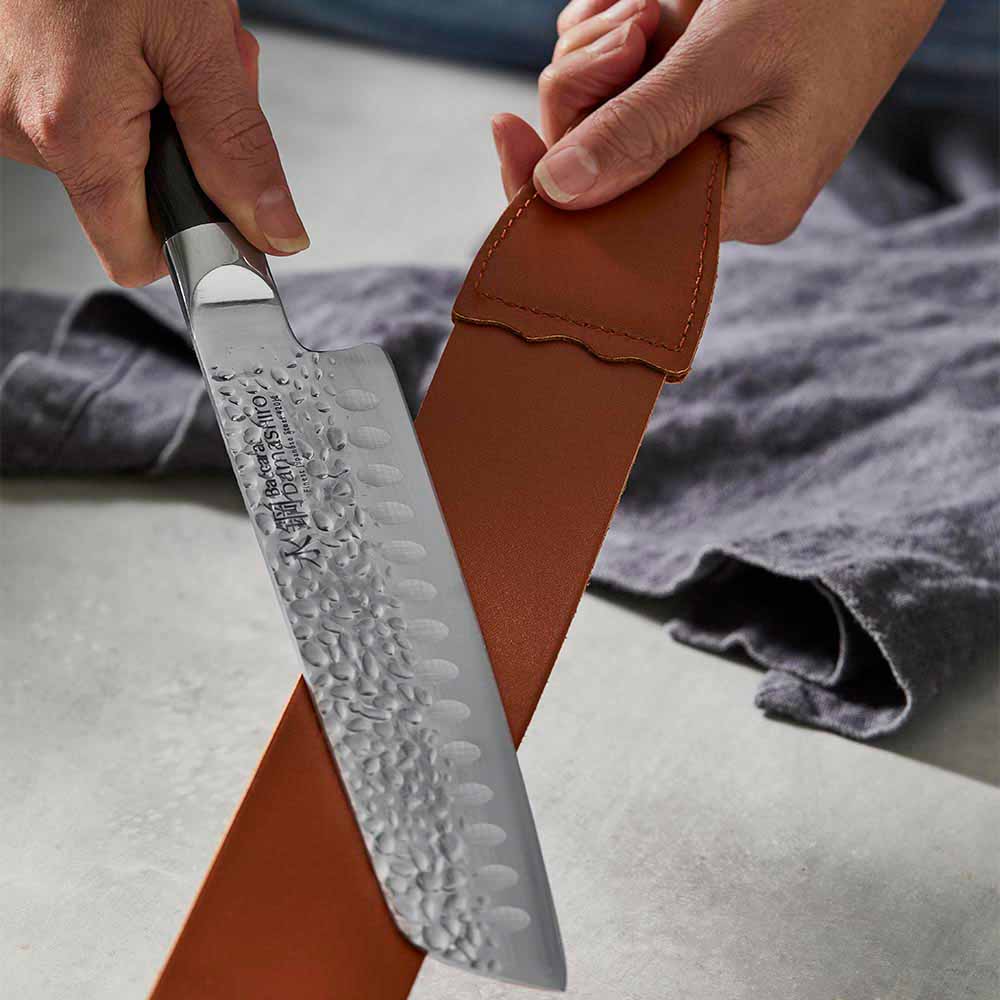 woman polishing knife with leather strop - MyHouse