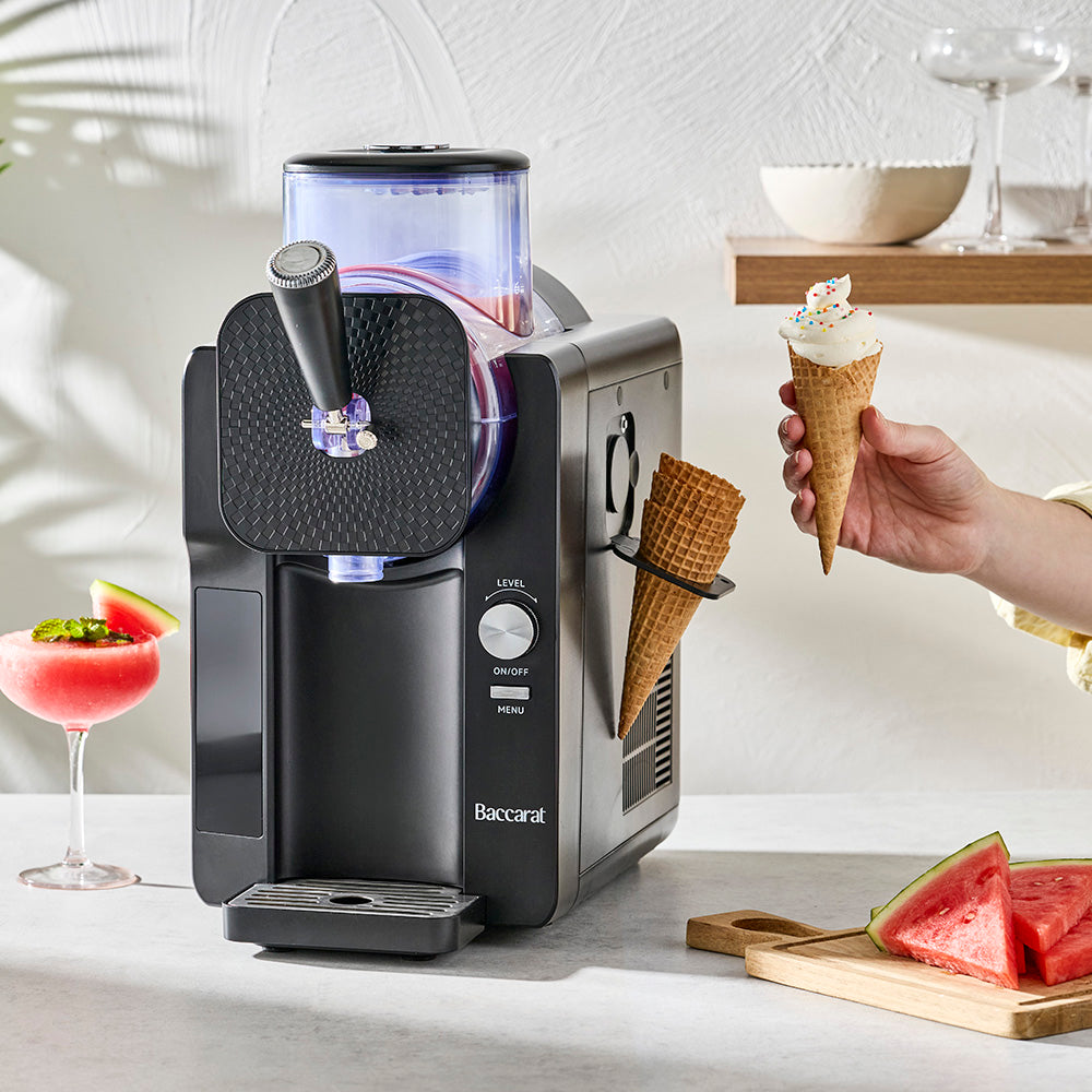 person holding ice cream next to an soft serve ice cream machine