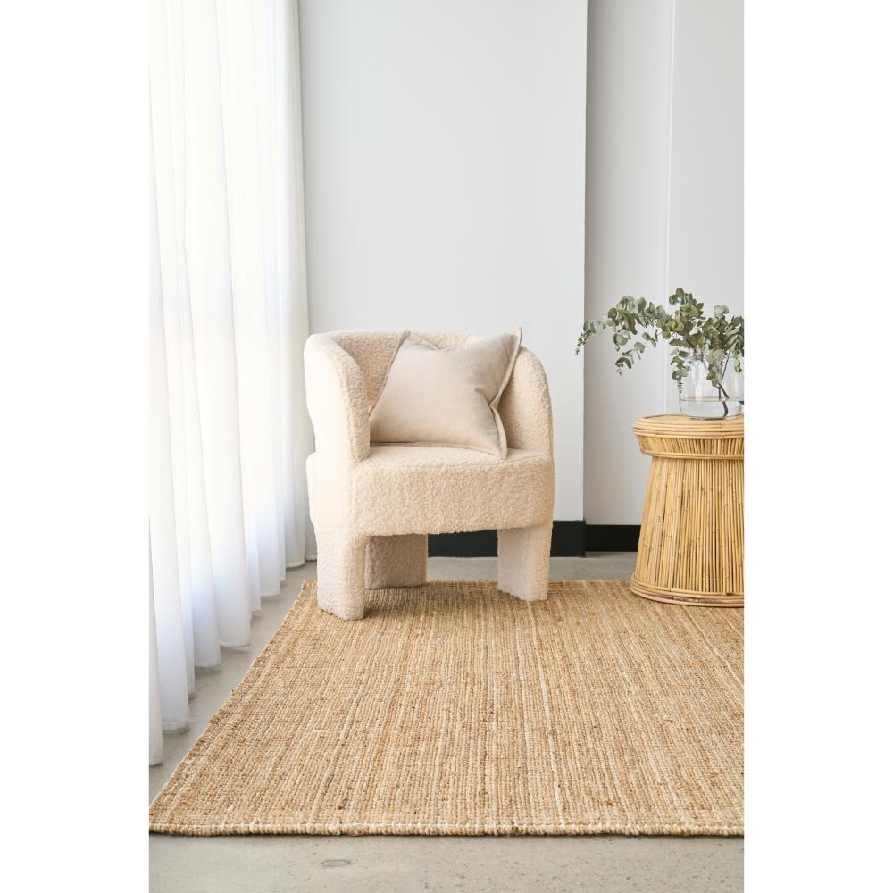 Natural brown jute rug with boucle chair and wicker table - MyHouse