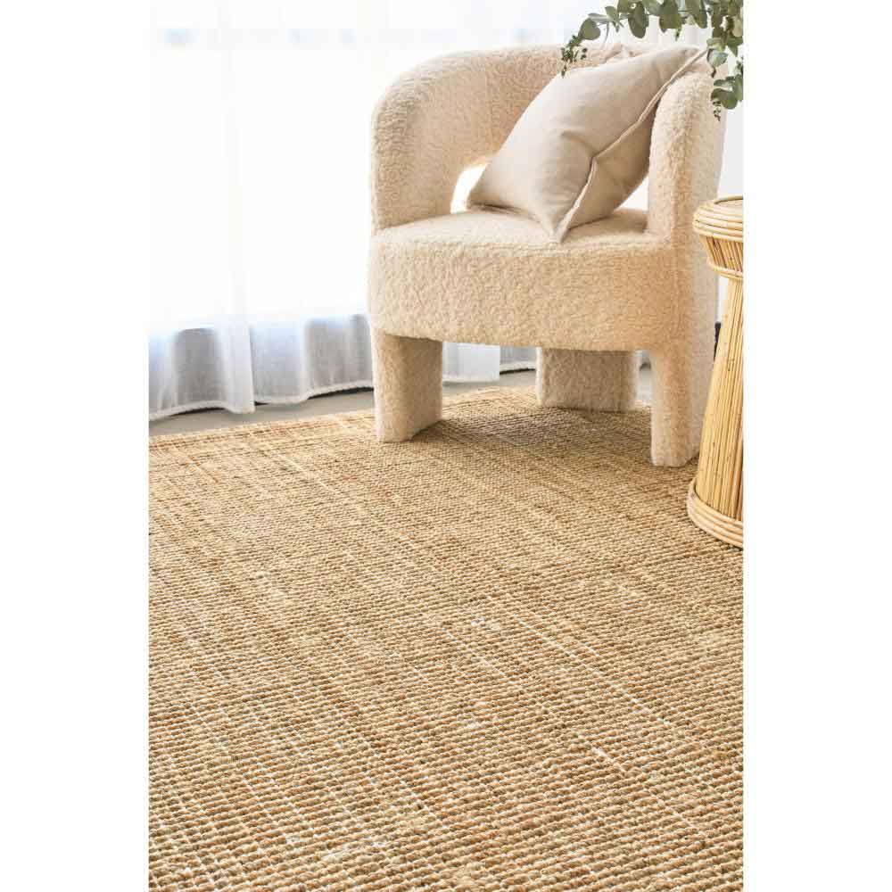 Natural brown jute rug with boucle chair and wicker table - MyHouse