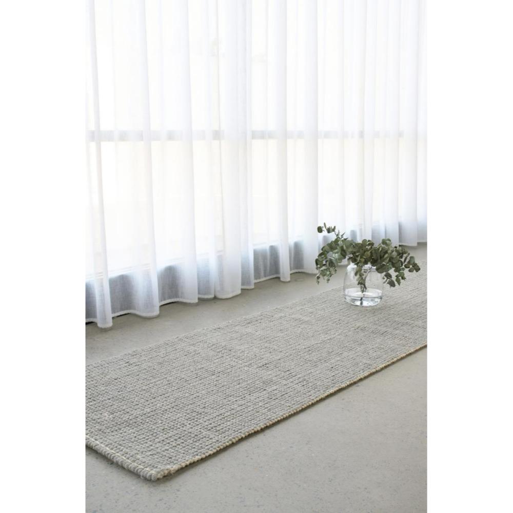 grey Hamptons style jute wool rug by a window - MyHouse