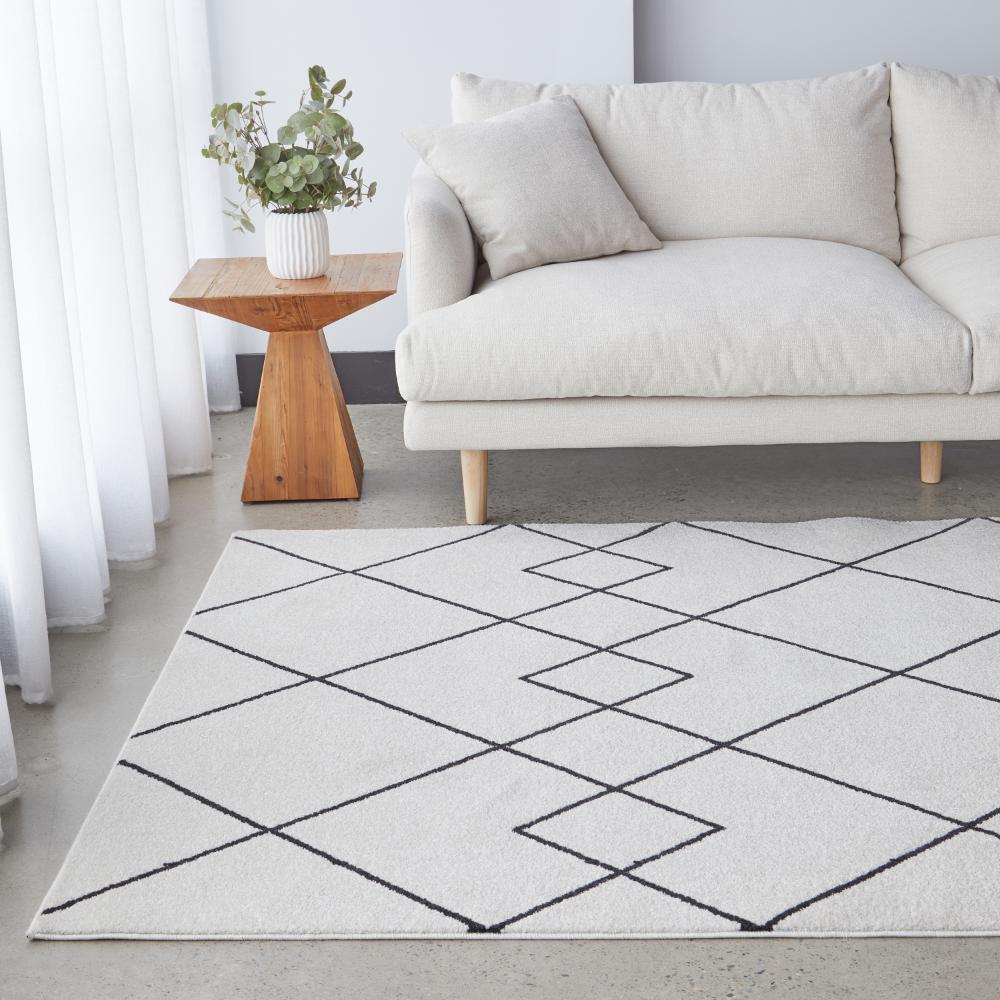 grey abstract rug with cream lounge and wooden side table - MyHouse