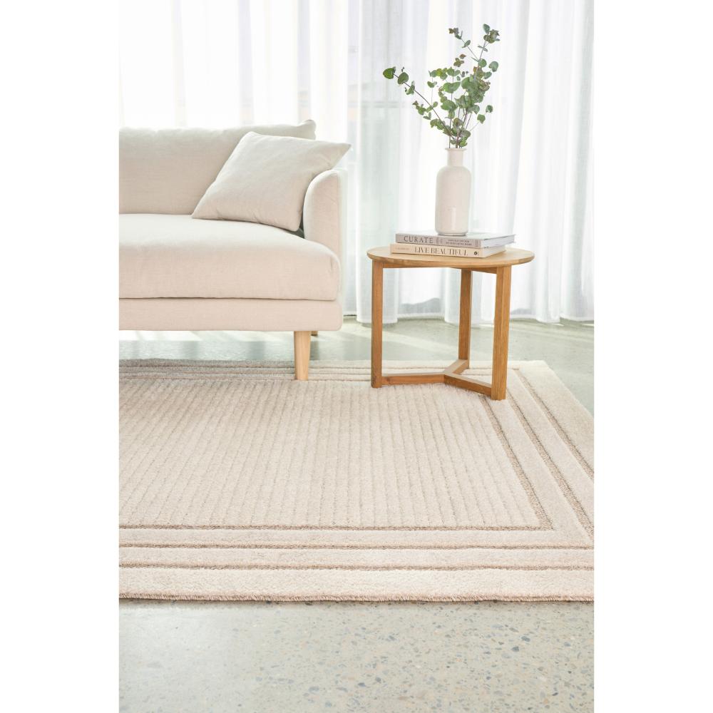 cream beige rug with triple border with lounge and table - MyHouse