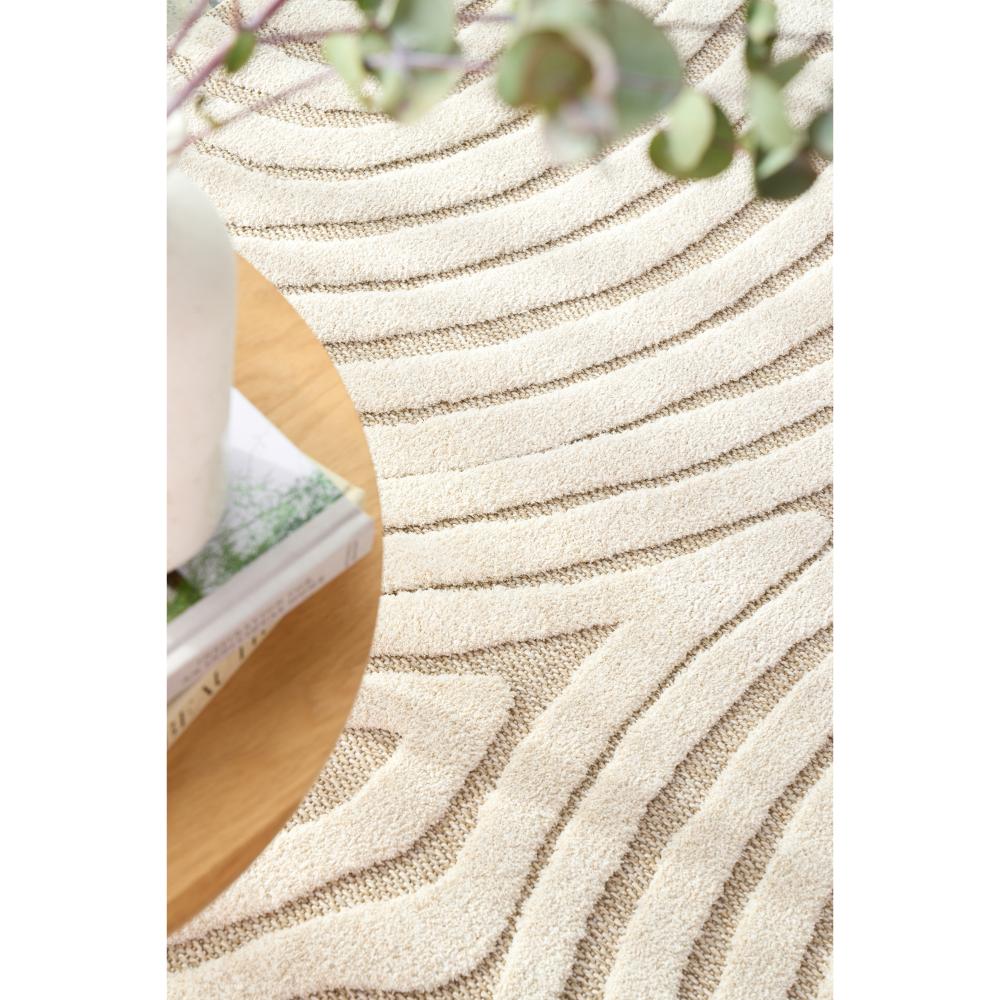 Natural beige swirl rug with side table, books, and vase - MyHouse