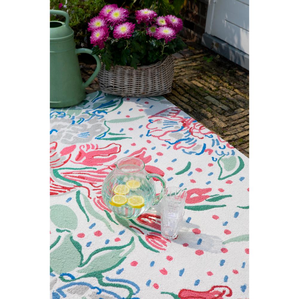 floral indoor/outdoor rug in backyard with a a jug of water - MyHouse