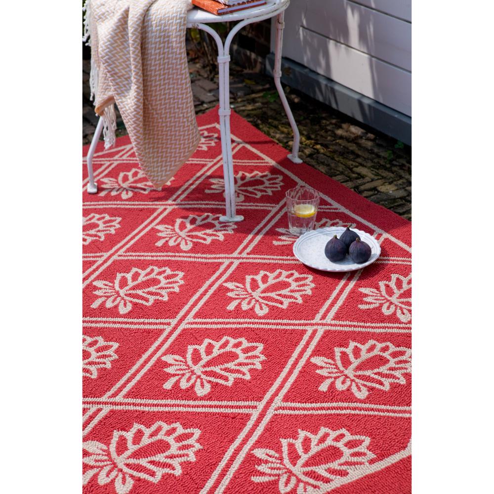 red floral outdoor rug in backyard with chair and throw - MyHouse