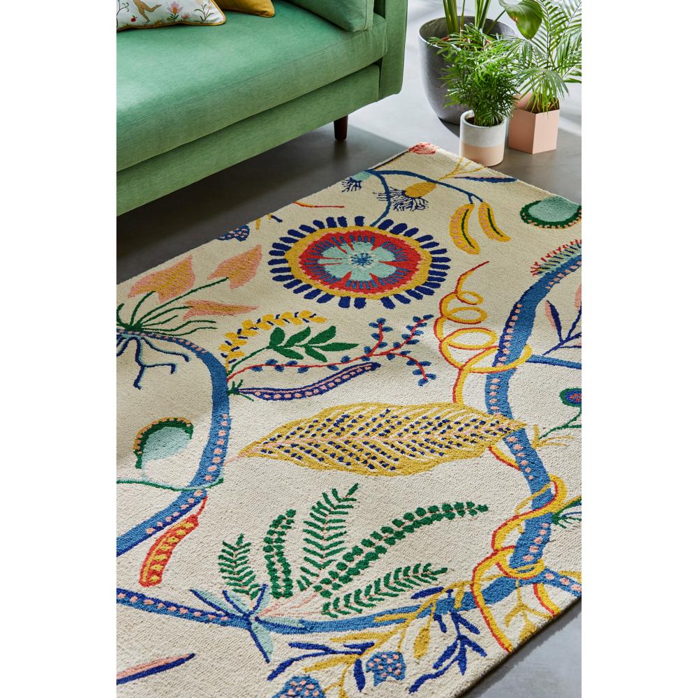 multicolour floral rug with green couch - MyHouse