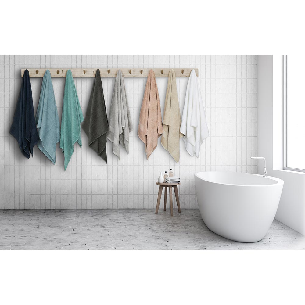 Algodon St Regis Bath Towels at MyHouse. Bath towels hanging wooden hooks next to a bath.