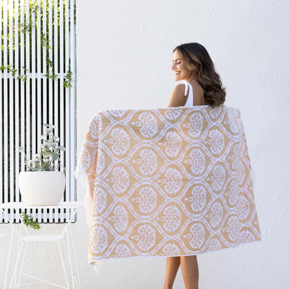 woman posing with cream and white boho print beach towel
