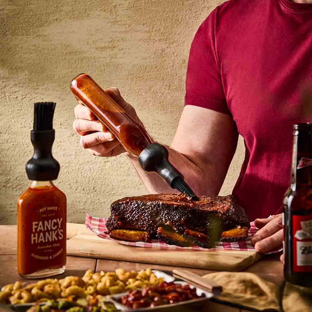 man basting steak with basting bottle cap brush - MyHouse