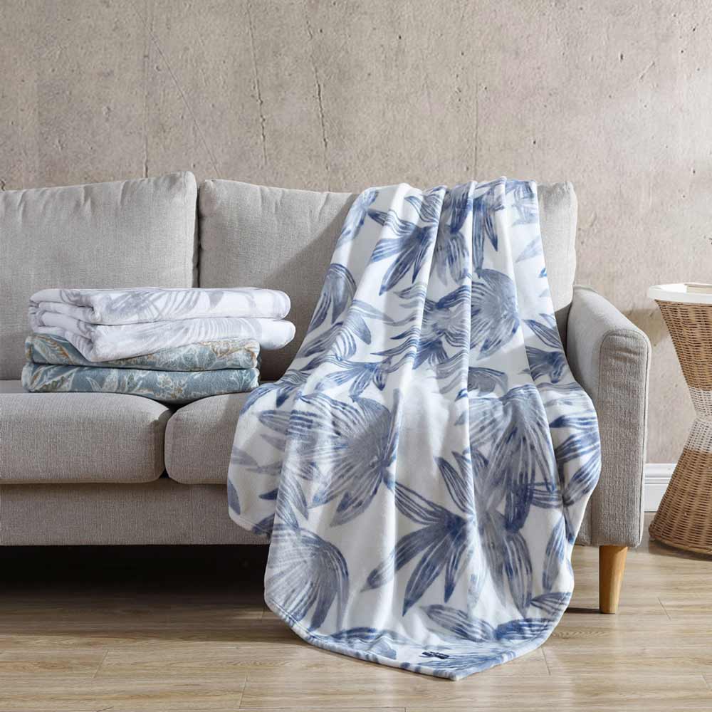Tommy Bahama Kayo Blanket Canal Blue draped over a couch at MyHouse