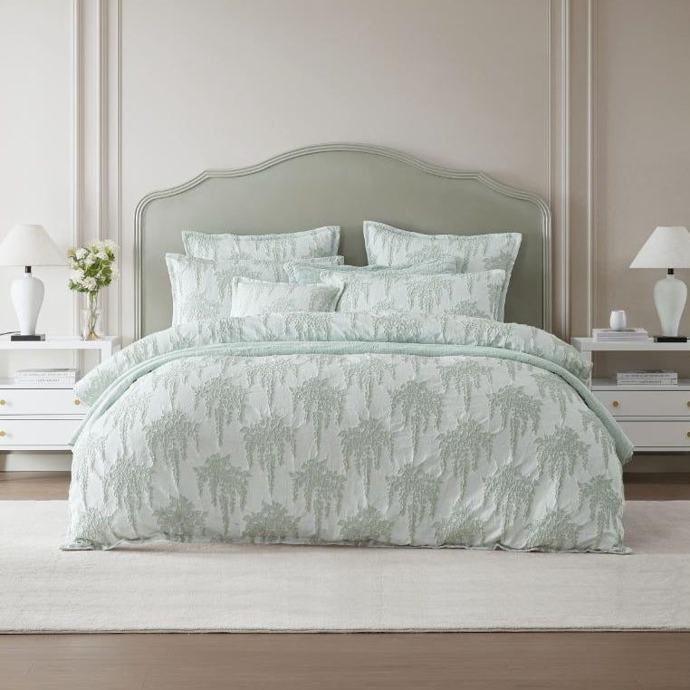 Bed with green floral bedding in a bedroom setting