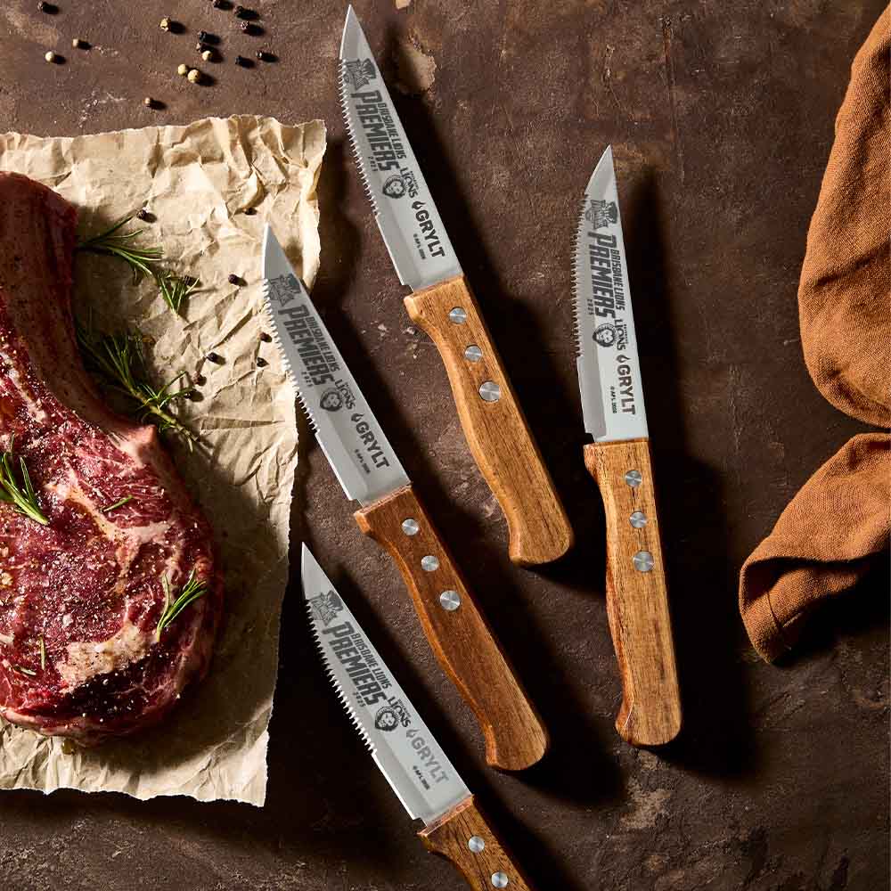 AFL Premiers 2025 Brisbane Lions Steak Knife Set on counter with porterhouse