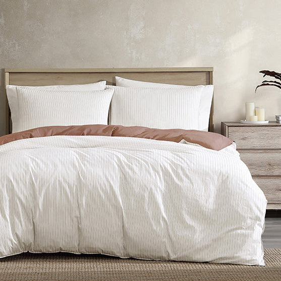 Bedroom with a neatly made bed, nightstands, and decor items.
