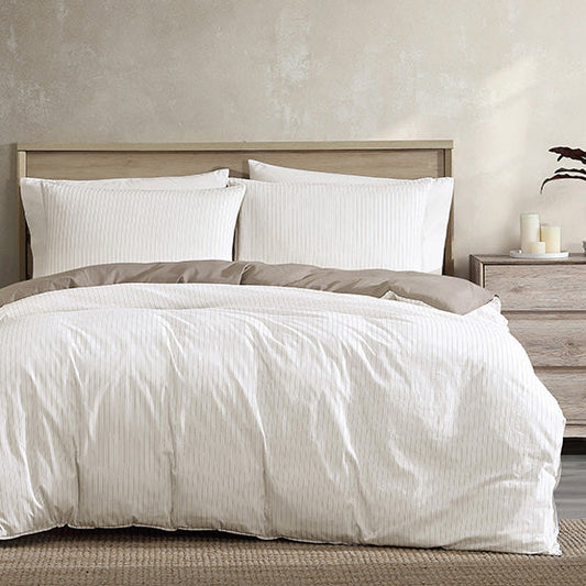 Neatly made bed with white bedding in a bedroom setting.
