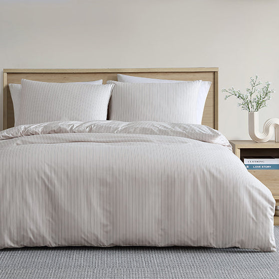 Neatly made bed with white bedding in a bedroom setting.