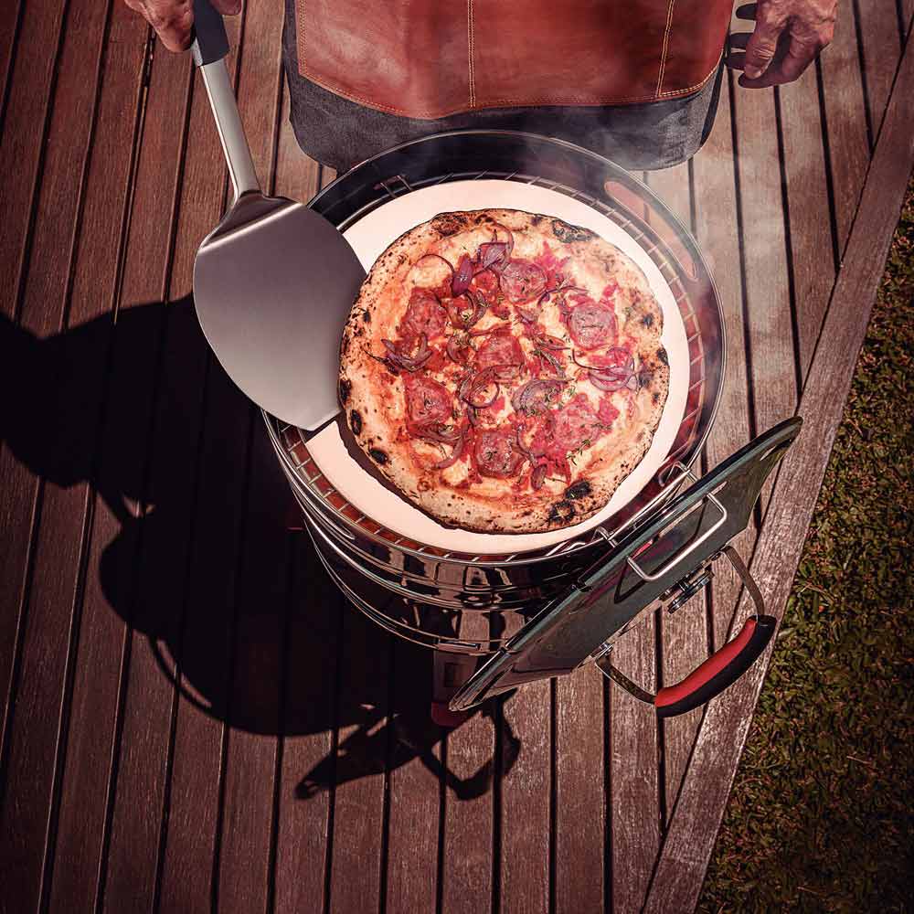 Man cooking pizza on bbq with pizza spatula - MyHouse