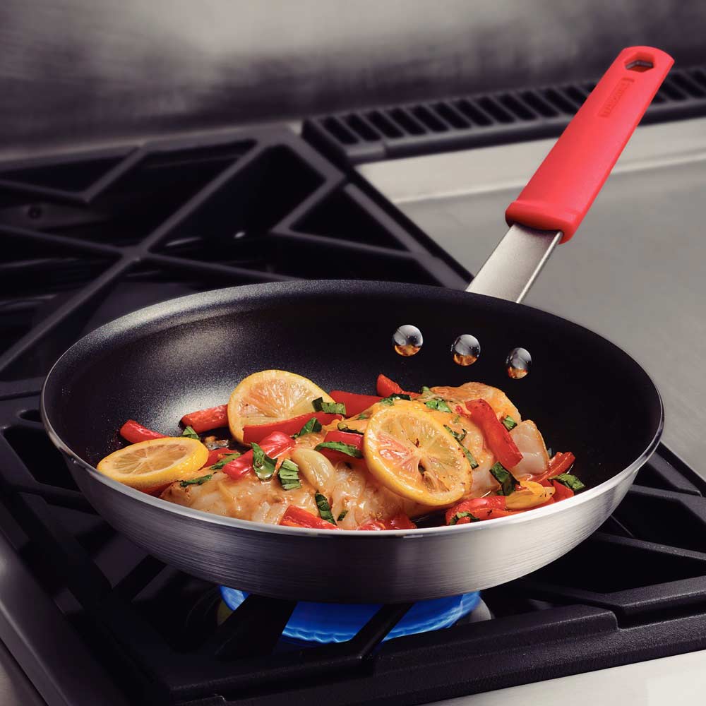 25cm frypan with red handle cooking fish on hotplate - MyHouse