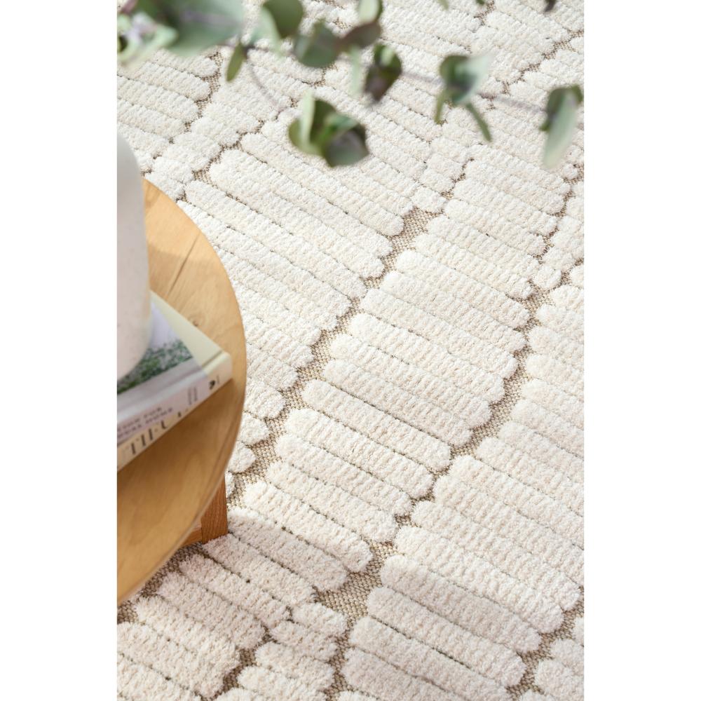 Natural beige waves rug with side table, books and vase - MyHouse
