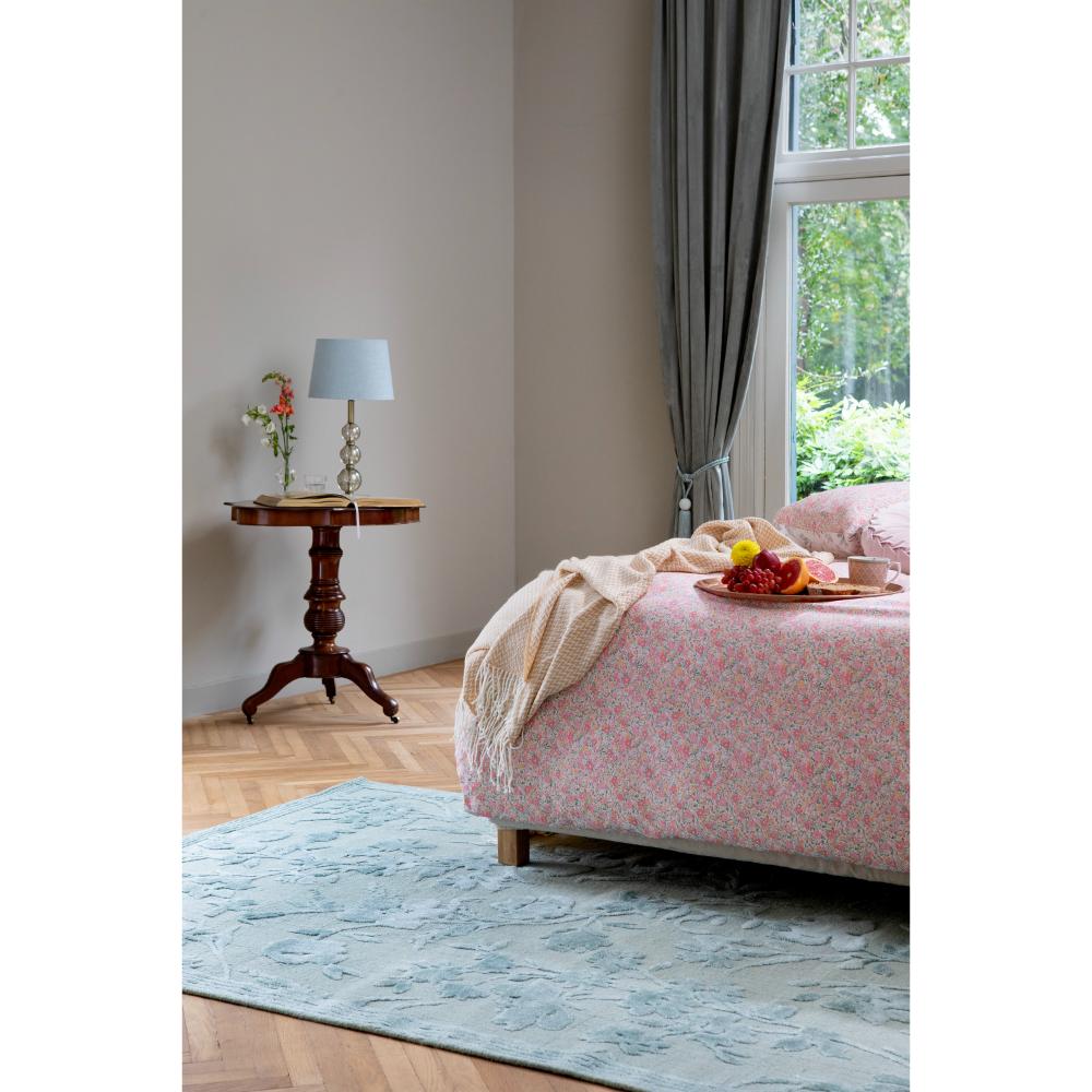 sage green flower rug in bedroom with bed and table - MyHouse